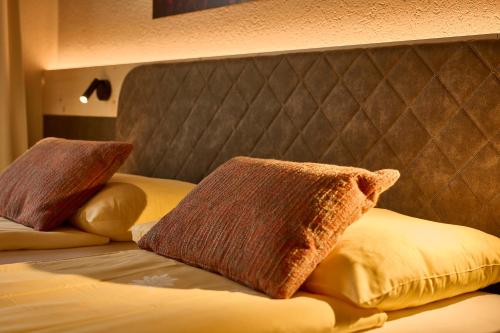 a bed with two pillows on top of it at Hotel Central Wolter - Grindelwald in Grindelwald