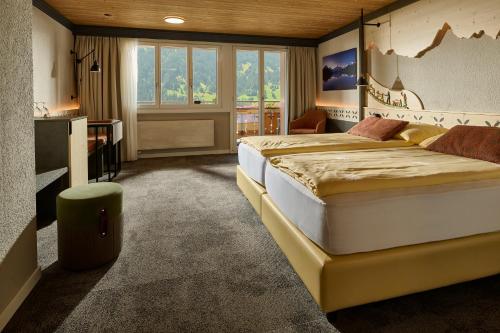 Una habitación de hotel con dos camas y un televisor. en Hotel Central Wolter - Grindelwald, en Grindelwald