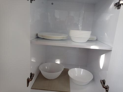 a kitchen with white bowls and plates on shelves at דצ'א - Дача - Dacha in El-Rom
