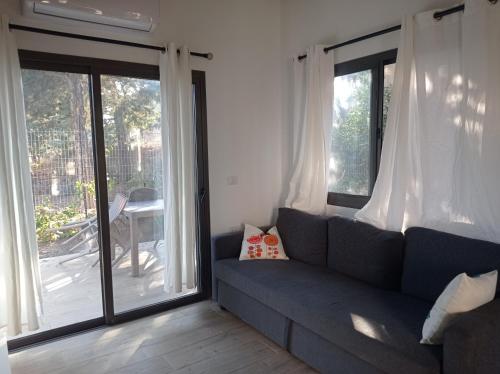 a living room with a couch and sliding glass doors at דצ'א - Дача - Dacha in El-Rom