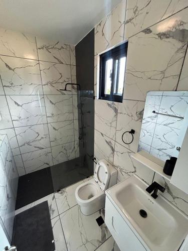 un bagno bianco con lavandino e WC di Level suites Penthouse a Sosúa