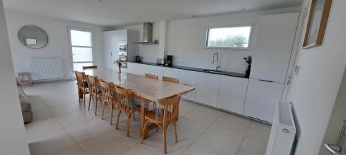 une cuisine avec une table et des chaises dans une pièce dans l'établissement MoLiMa 500m de la mer, à Loctudy