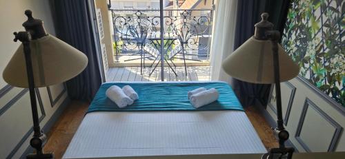 a room with two lamps and a bench in front of a window at Hôtel Villa-Lamartine in Arcachon