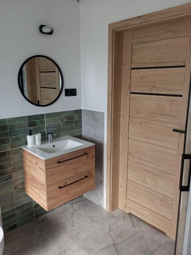 a bathroom with a sink and a wooden door at Cracow house under walnut tree in Kraków