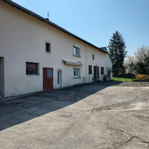 - un bâtiment blanc avec une allée devant dans l'établissement La Ferme, à Arinthod