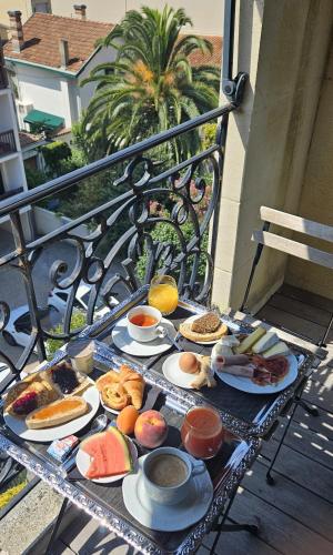 a tray of breakfast foods on a table on a balcony at Hôtel Villa-Lamartine in Arcachon