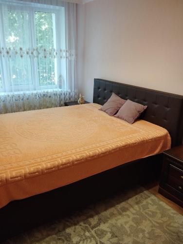 a bed in a bedroom with a large window at Comfortable apartment in the center of Ungheni in Ungheni