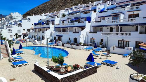 a group of white buildings with a swimming pool at Cozy apartment with wonderful view - Los Cristianos in Arona