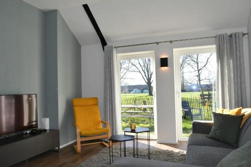 a living room with a couch and a television at Appartementen Chaamse Bossen met tuin in Chaam