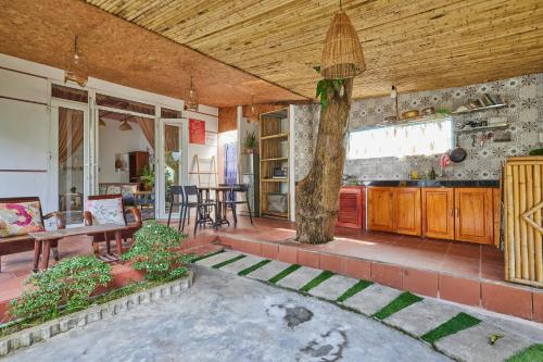 a living room with a table and a tree in it at Bamboo Garden House By Hoa in An Bang