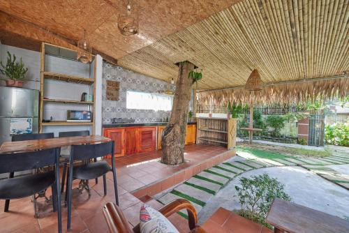 a kitchen with a table and a tree in it at Bamboo Garden House By Hoa in An Bang