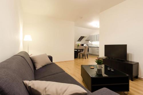 a living room with a couch and a table at Pension Zličín in Prague