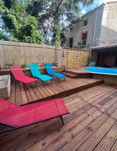 une terrasse en bois avec des chaises et une piscine dans l'établissement Superbe Villa avec piscine, 4 chambres à Vinassan, à Vinassan