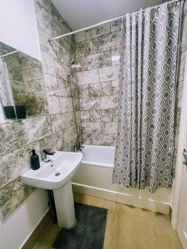 a bathroom with a sink and a tub and a shower at Bay Wind Apartment in Morecambe