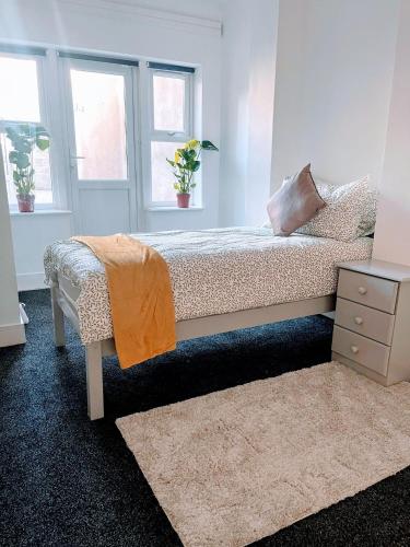 a bedroom with a bed and two windows at Bay Wind Apartment in Morecambe