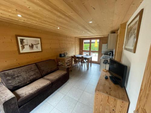 Una sala de estar con un sofá y una mesa con televisión. en Chalet Aravis, en Le Grand-Bornand
