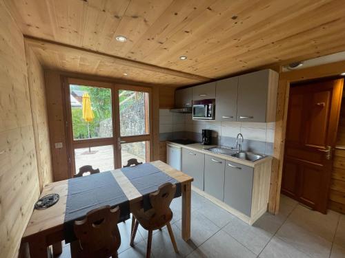 Una cocina con mesa y sillas en una cabaña. en Chalet Aravis, en Le Grand-Bornand