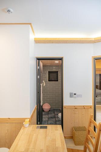 a room with a table and a walk in shower at Le Village Aewol building A in Jeju