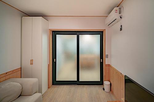 a room with a sliding glass door in a room at Le Village Aewol building A in Jeju