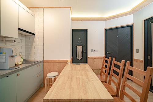 a kitchen with a wooden table and chairs at Le Village Aewol building A in Jeju