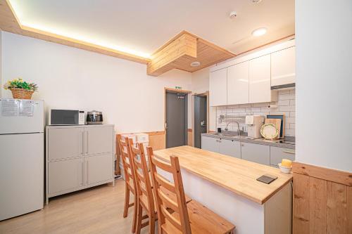 a kitchen with a table and chairs and a refrigerator at Le Village Aewol building A in Jeju