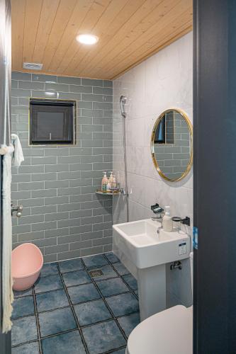 a bathroom with a sink and a toilet and a mirror at Le Village Aewol building A in Jeju