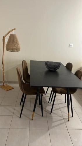 une table à manger avec des chaises et une lampe dans l'établissement Dream appartement!! spacieux ,calme au rez-de-chaussée, à Bourg-en-Bresse