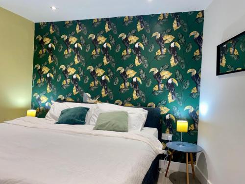 a bedroom with a bed with a green wall at Apartment 3 in Manchester