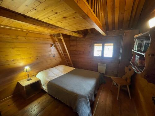 une chambre avec un lit dans une cabane en bois dans l'établissement Chalet Aravis, au Grand-Bornand