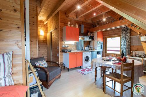 - une cuisine et une salle à manger dans une cabane en rondins dans l'établissement Le Petit Renard, à Ancelle