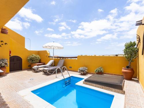 a patio with a swimming pool and a yellow wall at Live Arico El Mirador in Arico el Nuevo