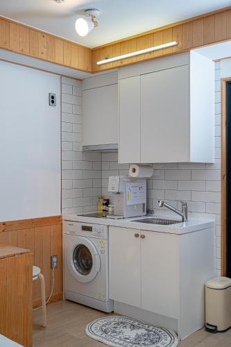 a kitchen with a washing machine and a sink at Le Village Aewol building A in Jeju
