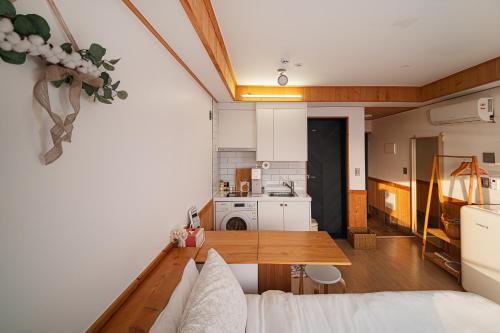 a living room with a table and a kitchen at Le Village Aewol building A in Jeju