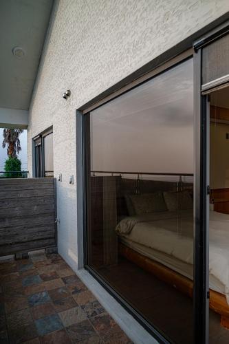 a bedroom with a large glass window with a bed at Le Village Aewol building A in Jeju
