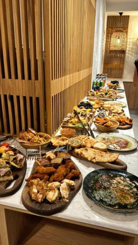 a long table with many plates of food on it at Hotel Serenity Timisoara in Timişoara