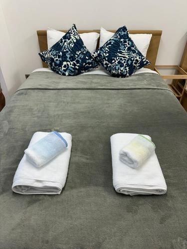 a bed with two towels and pillows on it at JR Shin-Osaka 30s, Direct to Kansai Airport 關西空港直達,Shinkansen to Tokyo, Tokyo & Nagoya, Universal Studio 16 mins, Umeda 6 mins, Kyoto 25 mins, Early Check-In in Osaka