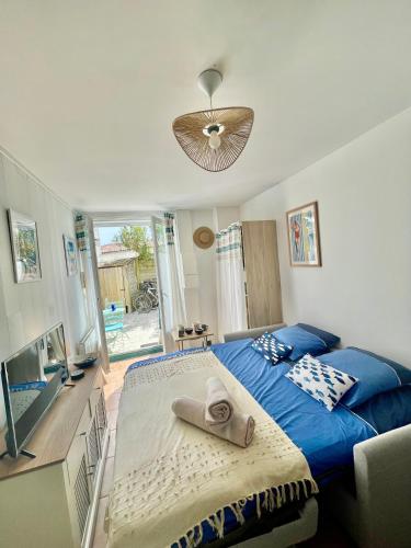 - une chambre avec un lit bleu et une serviette dans l'établissement Le Nid Flottais, à La Flotte