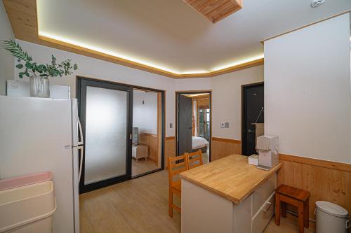 a kitchen with a refrigerator and a table with a counter at Le Village Aewol building A in Jeju