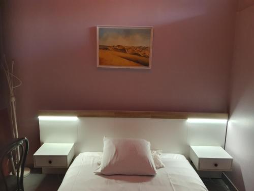 - une chambre avec un lit et 2 tables de nuit blanches dans l'établissement confort appartement, à Conflans-Sainte-Honorine