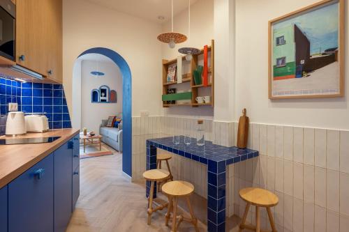 une cuisine avec un comptoir en carrelage bleu et des tabourets dans l'établissement New Mediterranean-Style T2 -Greater Paris district, à Malakoff