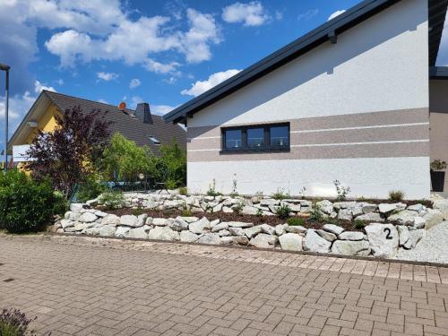 a stone retaining wall next to a house at Ferienhaus Kleine Auszeit in Idar-Oberstein