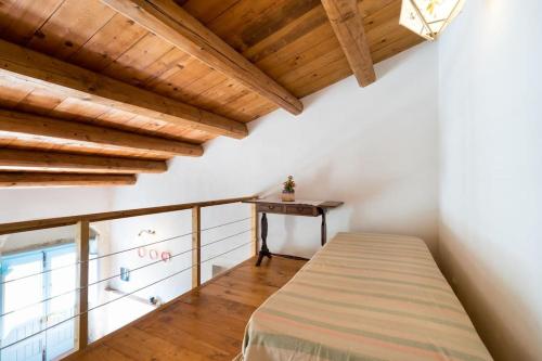 a bedroom with a bed in a room with wooden ceilings at Casa Sarculla in Testa dellʼAcqua