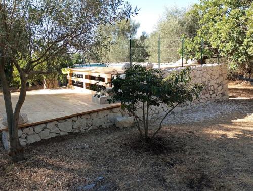 a stone bench in a yard with a tree at Casa Sarculla in Testa dellʼAcqua