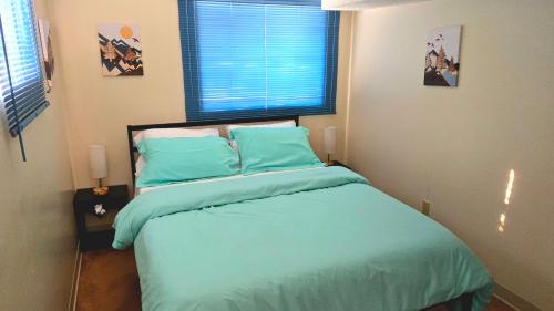 a bedroom with a bed with blue sheets and a window at Booking - Hoskere Homes in Sandy