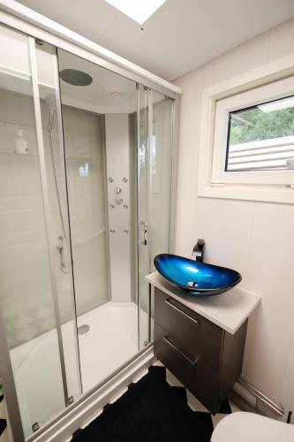 a bathroom with a blue sink and a shower at Evenes Artic glamping in Evenesmarkja