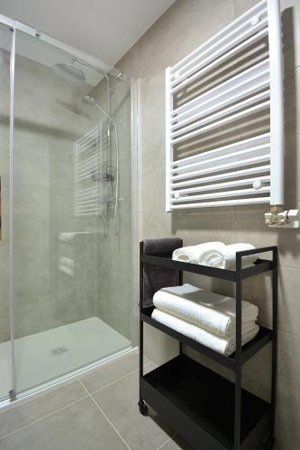 a bathroom with a shower and a rack with towels at GALIHOST - Apartamento en Playa de Compostela in Vilagarcia de Arousa