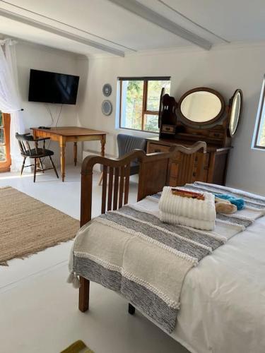 a bedroom with a bed and a table and a mirror at Stay at Molly in Prince Albert