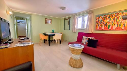 a living room with a red couch and a table at Costa do Castelo Terrace, em Rua dos Lagares 8 in Lisbon