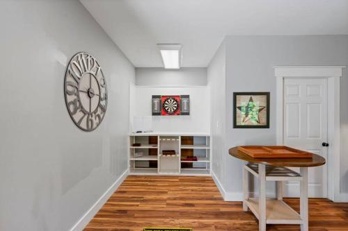 a white room with a table and a clock on the wall at Multi-gen Family Mountain House in Front Royal