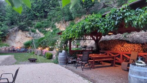 a patio with a table and chairs under a tree at Gästehaus Gerhardt in Schweigen-Rechtenbach